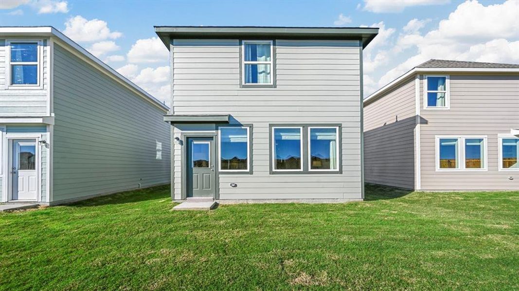 Rear view of property with a yard