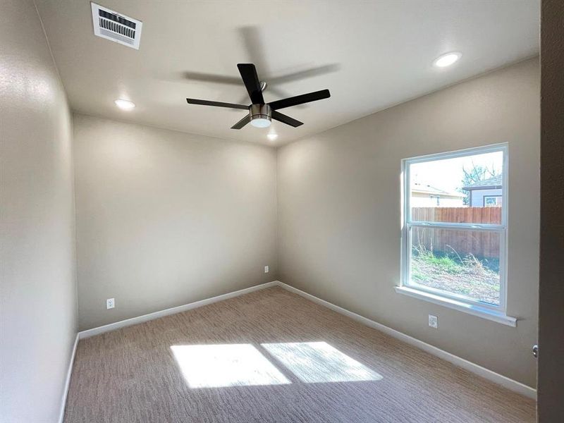 Spare room featuring light colored carpet and ceiling fan