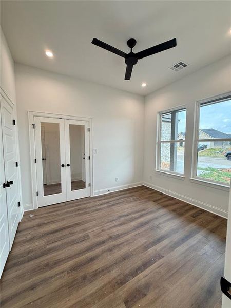 Unfurnished bedroom featuring french doors, a closet, dark wood-style floors, ceiling fan, and recessed lighting