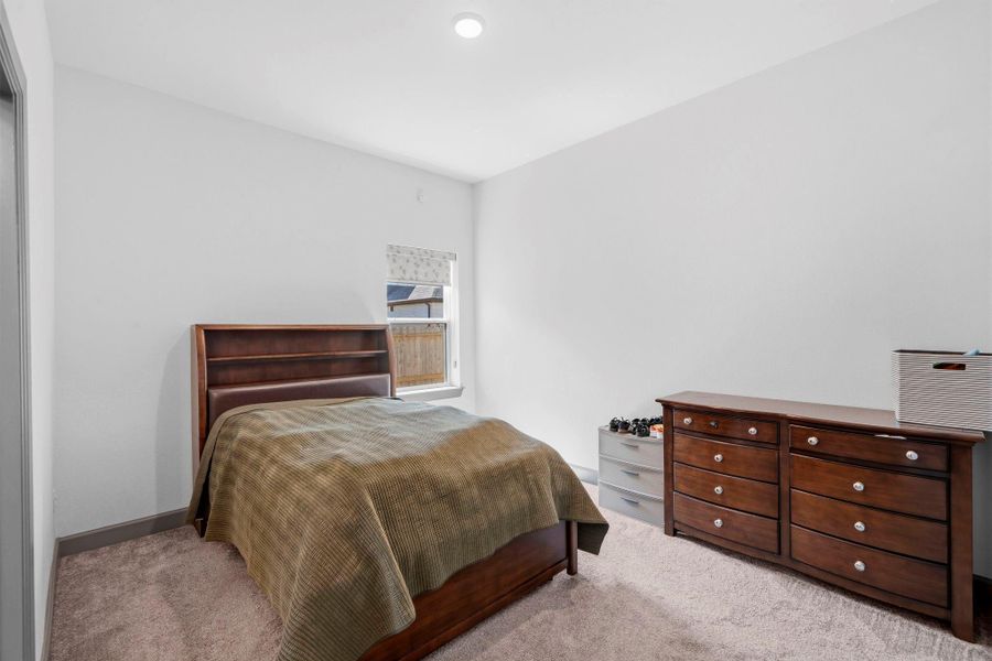 Comfortable secondary bedroom featuring plush carpeting, neutral tones, and a well-proportioned layout—offering a cozy and versatile space ideal for guests, family, or a home office.