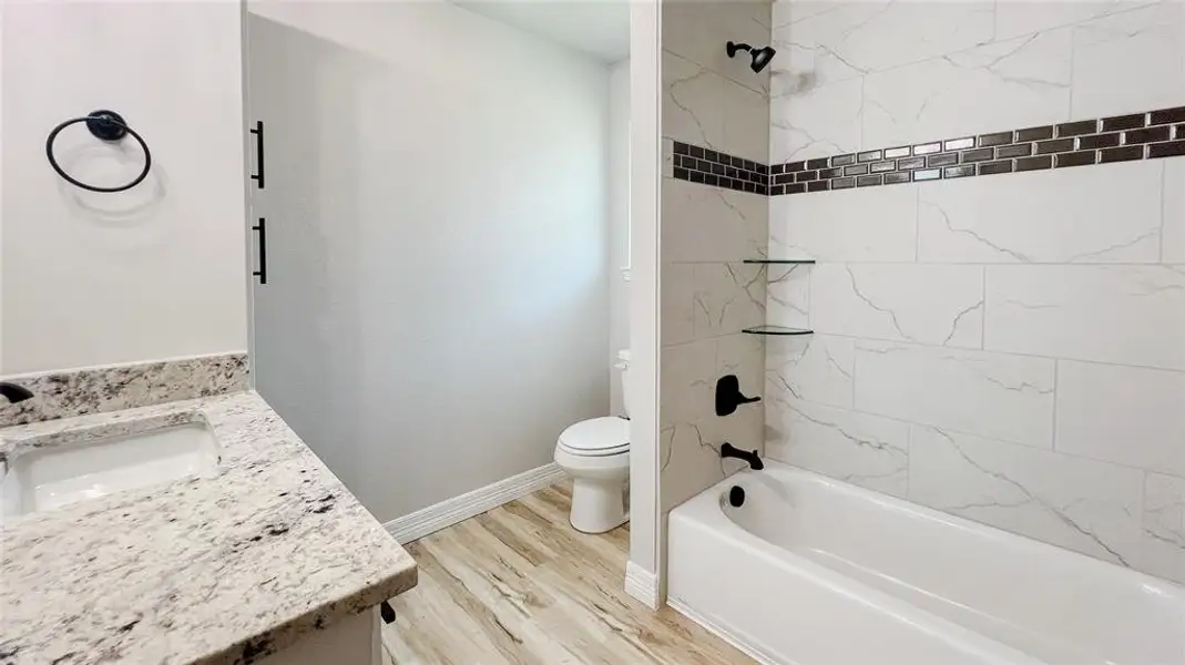 Bathroom with vanity, wood finished floors, and bathing tub / shower combination Bathroom with vanity, wood finished floors, and bathing tub / shower combination