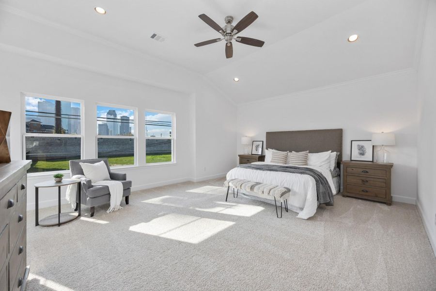 Step into a primary suite that lives like a luxury retreat—soaring ceilings, soft carpet underfoot, and a wall of windows bringing the outside in.