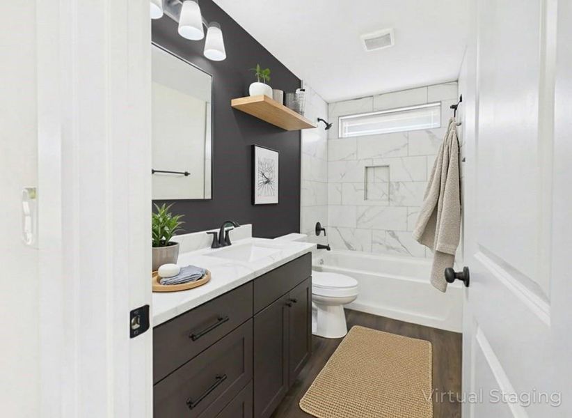 After photo featuring vanity, shower / bath combination, and dark wood finished floors