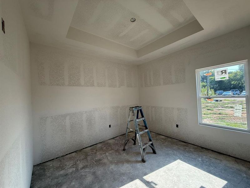 Empty room with a raised ceiling and concrete floors