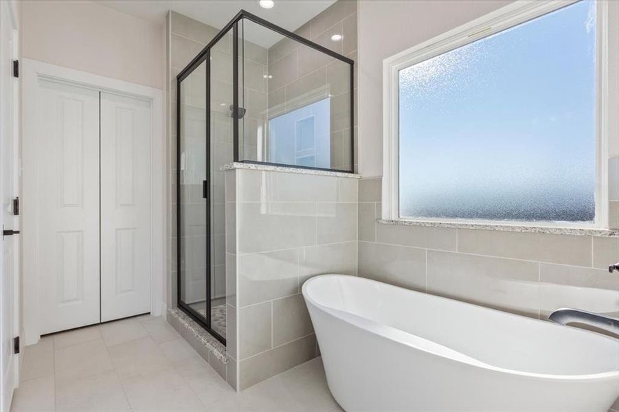 Full bathroom featuring a shower stall, a freestanding bath, tile walls, light tile patterned flooring, and recessed lighting Full bathroom featuring a shower stall, a freestanding bath, tile walls, light tile patterned flooring, and recessed lighting