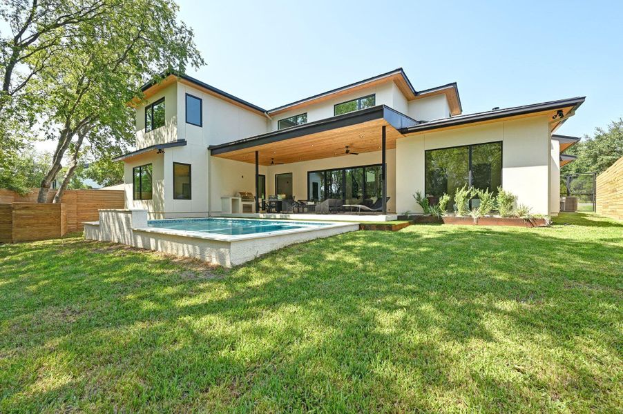 Rear view of property with a ceiling fan, a patio area, and stucco siding