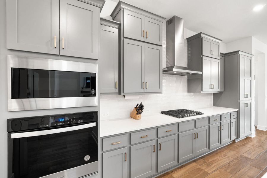 Culinary excellence awaits in this kitchen featuring abundant gray cabinetry, stainless steel appliances, and sleek countertops.