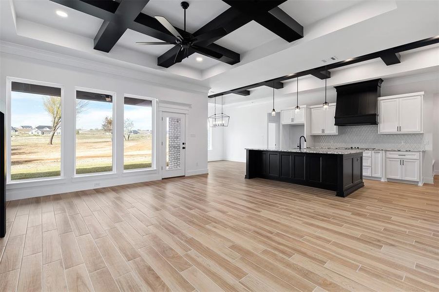 Kitchen featuring light hardwood / wood-style floors, coffered ceiling, beamed ceiling, white cabinets, and custom exhaust hood