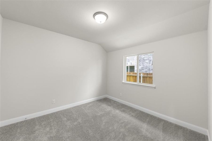 Spare room with carpet floors and lofted ceiling