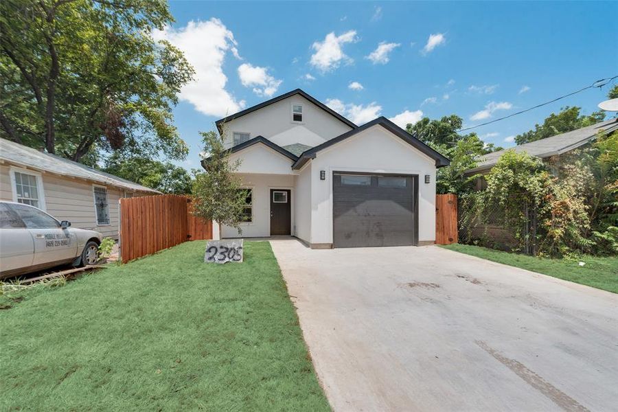 View of front of home with a garage and a front yard