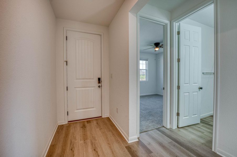 A welcoming entryway transitions smoothly into adjacent rooms with durable wood-look flooring.