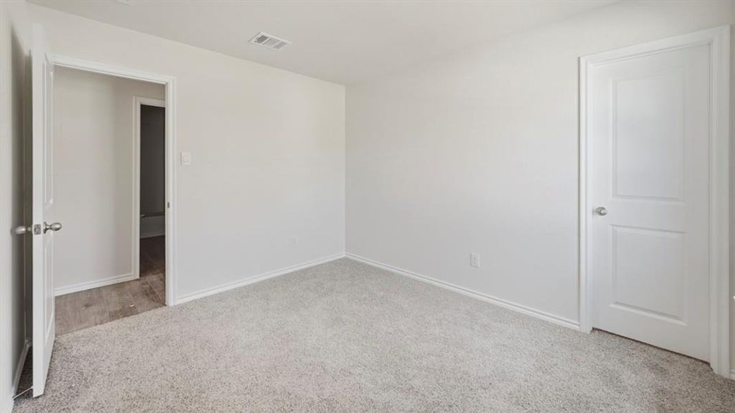Unfurnished bedroom featuring light colored carpet and baseboards
