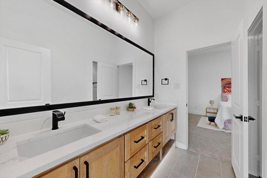 Full bath featuring double vanity, tile patterned flooring, and connected bathroom