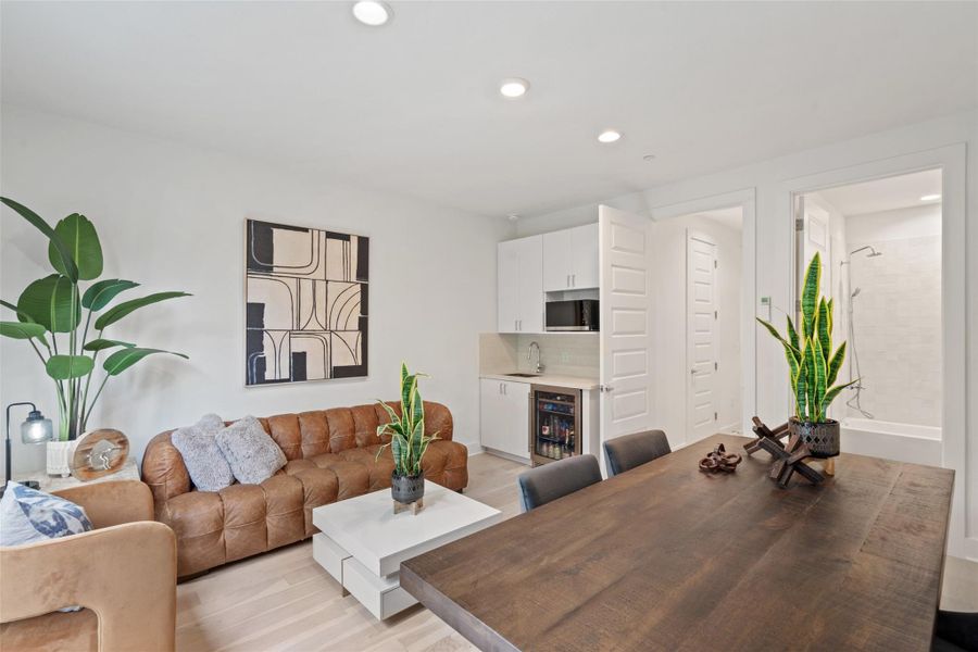 Living area with a bar, recessed lighting, light wood-type flooring, and wine cooler
