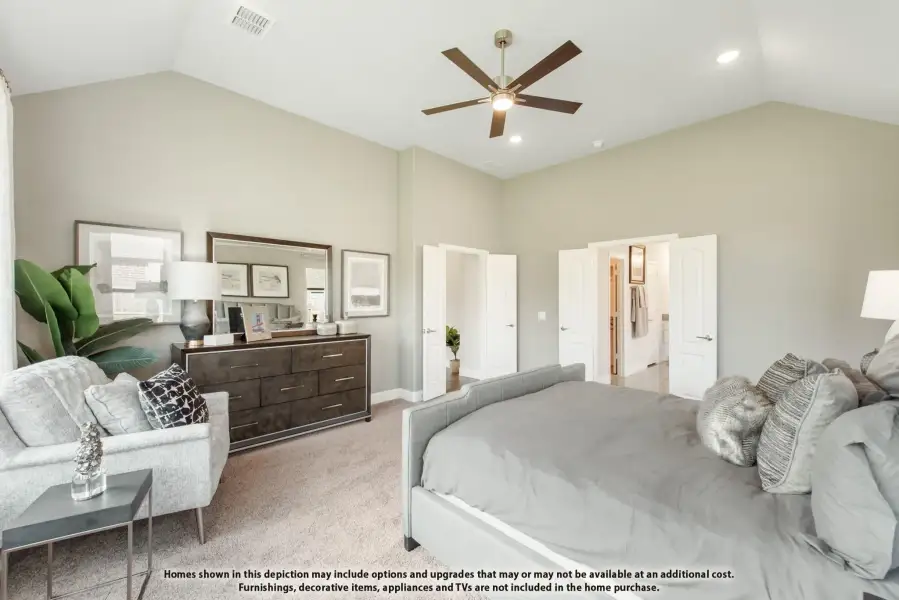 Master bedroom with vaulted ceiling, ceiling fan, carpet flooring, and doors leading to ensuite bathroom and closet.