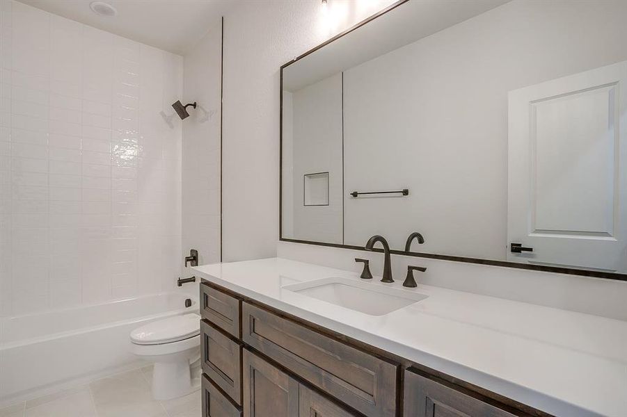 Full bath featuring vanity, shower / tub combination, and light tile patterned floors