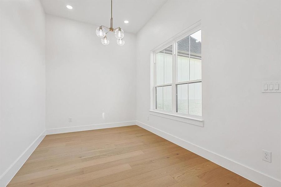 Empty room with an inviting chandelier, a wealth of natural light, and light wood-type flooring