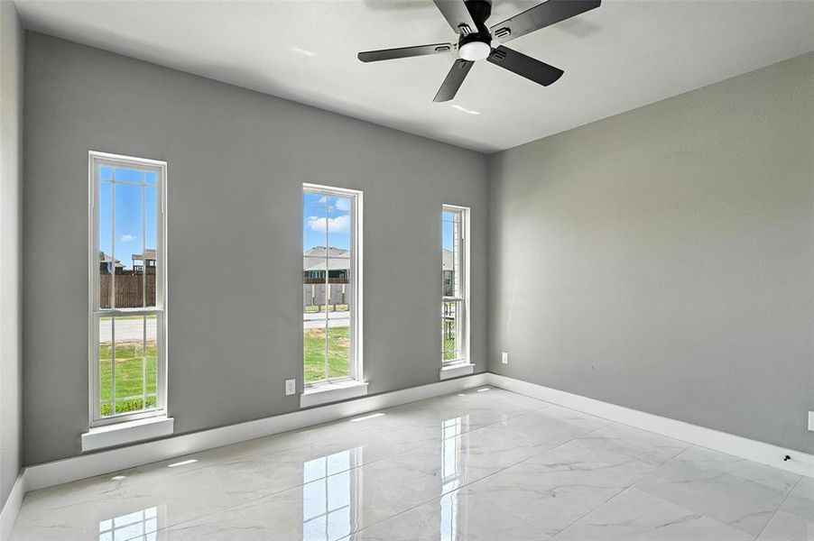 Empty room featuring light marble finish floors and ceiling fan Empty room featuring light marble finish floors and ceiling fan