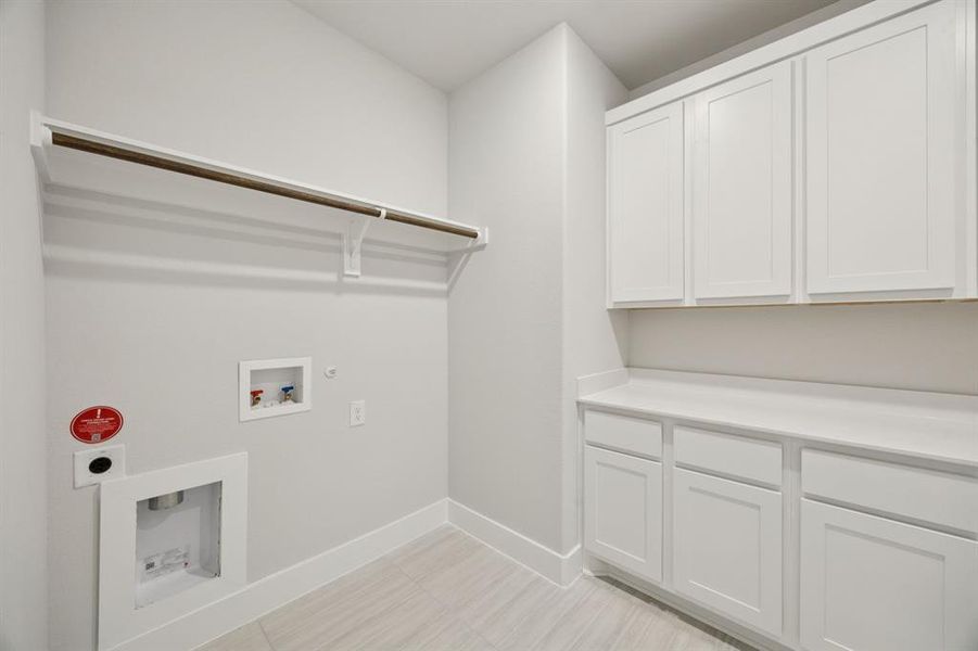 Washroom with hookup for a gas dryer, hookup for a washing machine, and electric dryer hookup