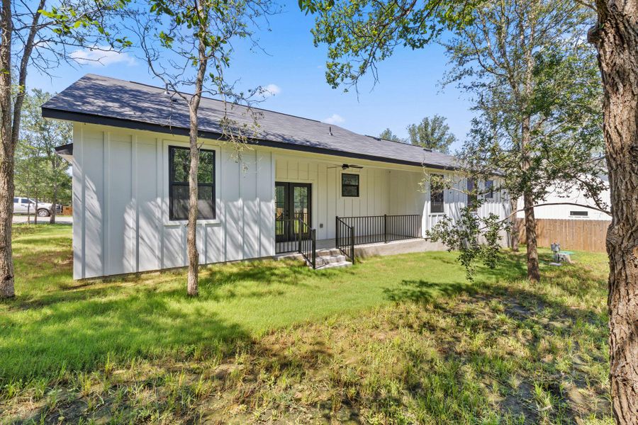 A striking modern farmhouse with vertical siding and a generous patio awaits. A striking modern farmhouse with vertical siding and a generous patio awaits.