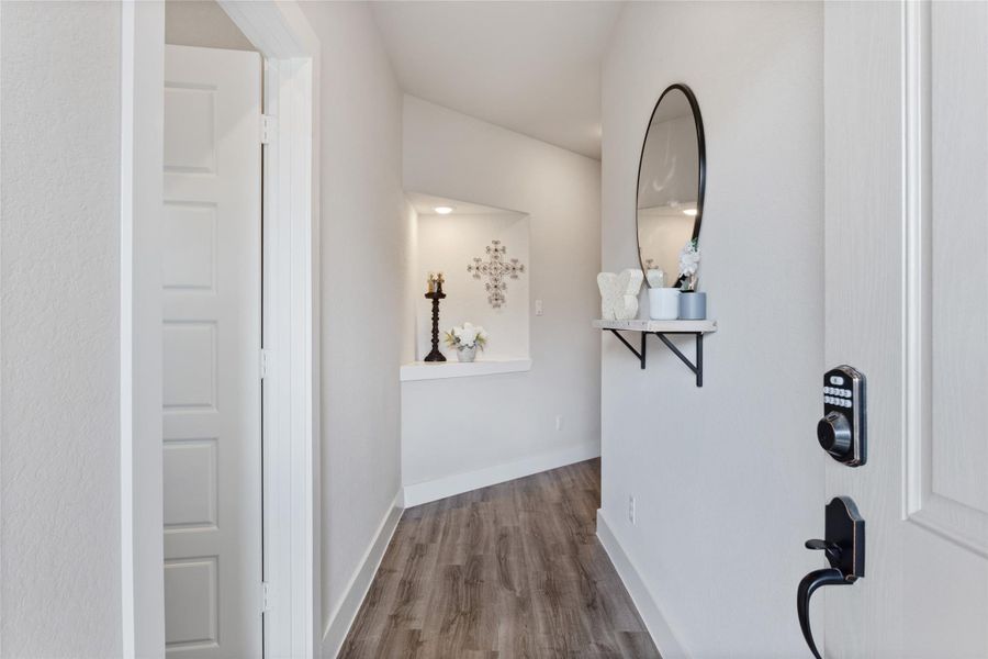 Welcome to your new home through this inviting front entryway, featuring elegant decor and warm wood flooring. Welcome to your new home through this inviting front entryway, featuring elegant decor and warm wood flooring.