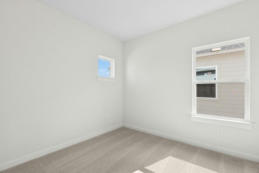 Spare room featuring carpet floors and baseboards