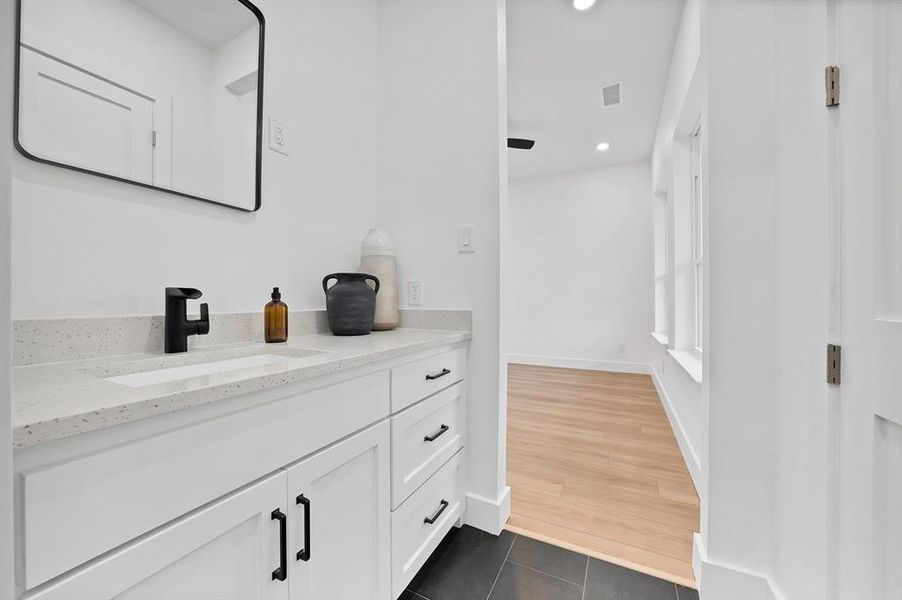 White vanity with quartz-finish countertop and integrated rectangular sink
