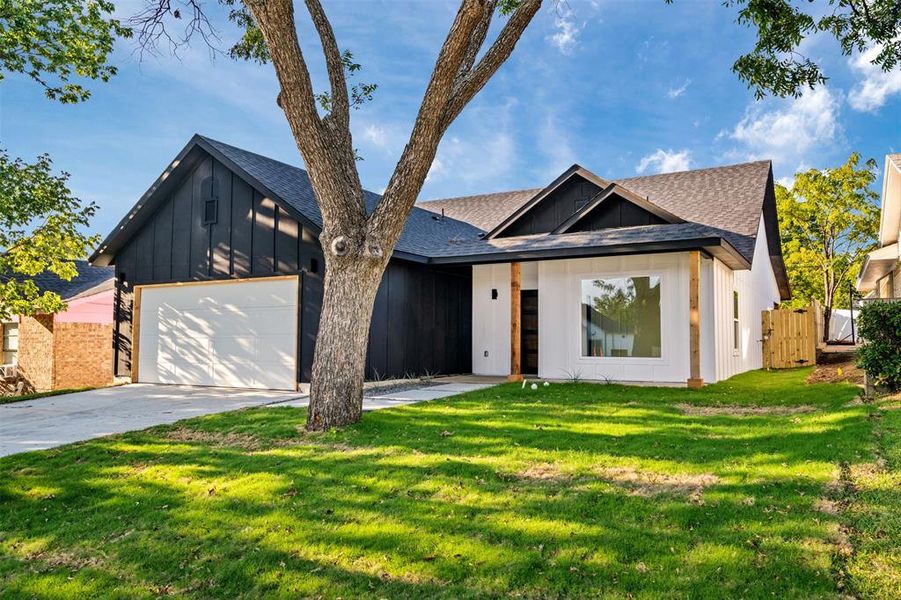 View of front of home featuring a garage and a front lawn