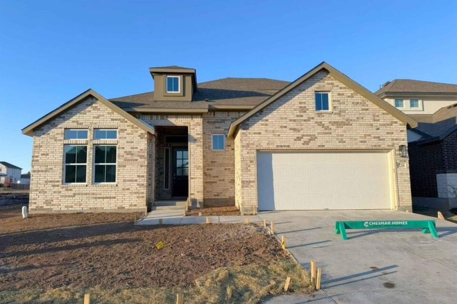 View of front facade featuring brick siding, concrete driveway, and a garage