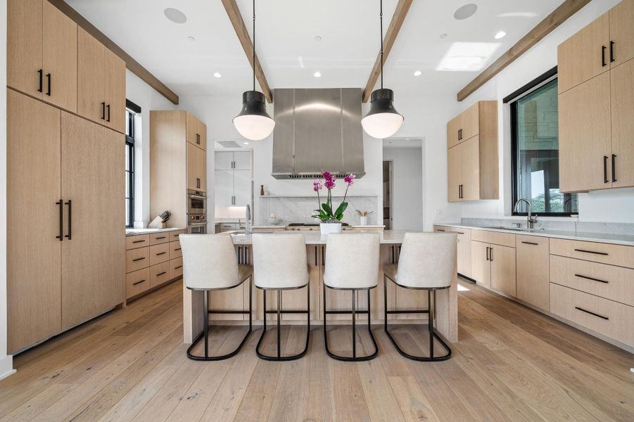 Kitchen with a sink, a breakfast bar area, light brown cabinetry, and beamed ceiling Kitchen with a sink, a breakfast bar area, light brown cabinetry, and beamed ceiling