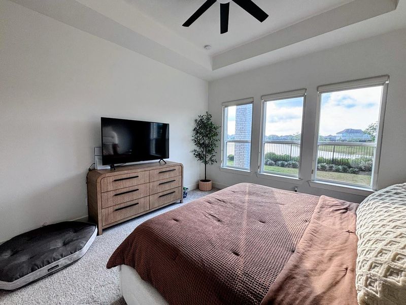 Bright master bedroom with large windows offering scenic views.