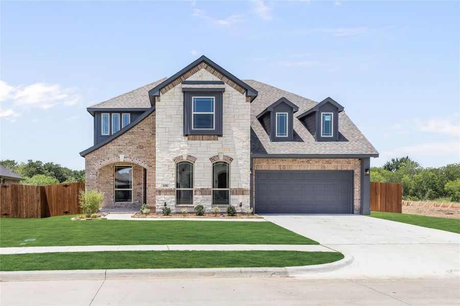 Two-story home with brick and stone exterior, two-car garage, and manicured front lawn Two-story home with brick and stone exterior, two-car garage, and manicured front lawn