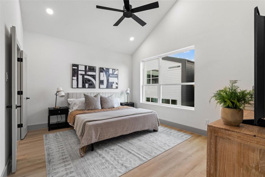 A peaceful primary retreat awaits—anchored by vaulted ceilings, wide-plank SPC flooring, and oversized windows that fill the space with natural light. The clean, modern aesthetic offers a calming backdrop for rest, recharge, and everyday luxury. A peaceful primary retreat awaits—anchored by vaulted ceilings, wide-plank SPC flooring, and oversized windows that fill the space with natural light. The clean, modern aesthetic offers a calming backdrop for rest, recharge, and everyday luxury.