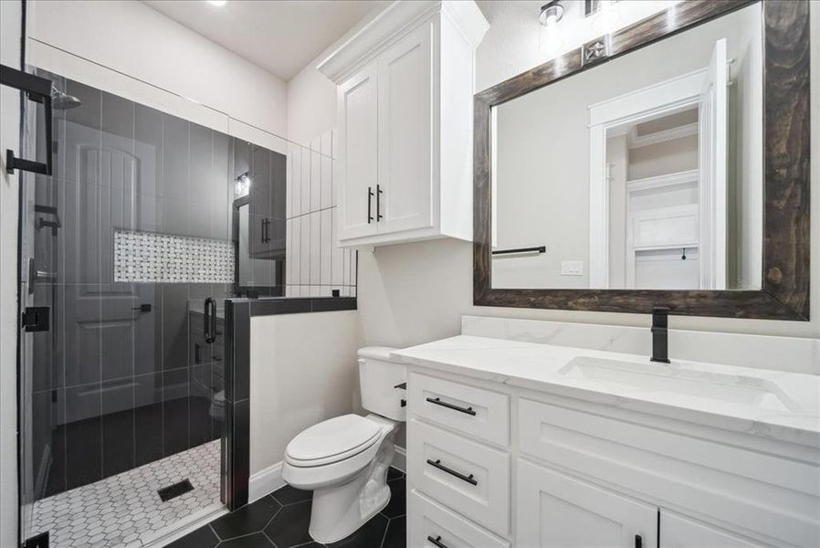 Bathroom with vanity, tile patterned flooring, a shower with door, and toilet