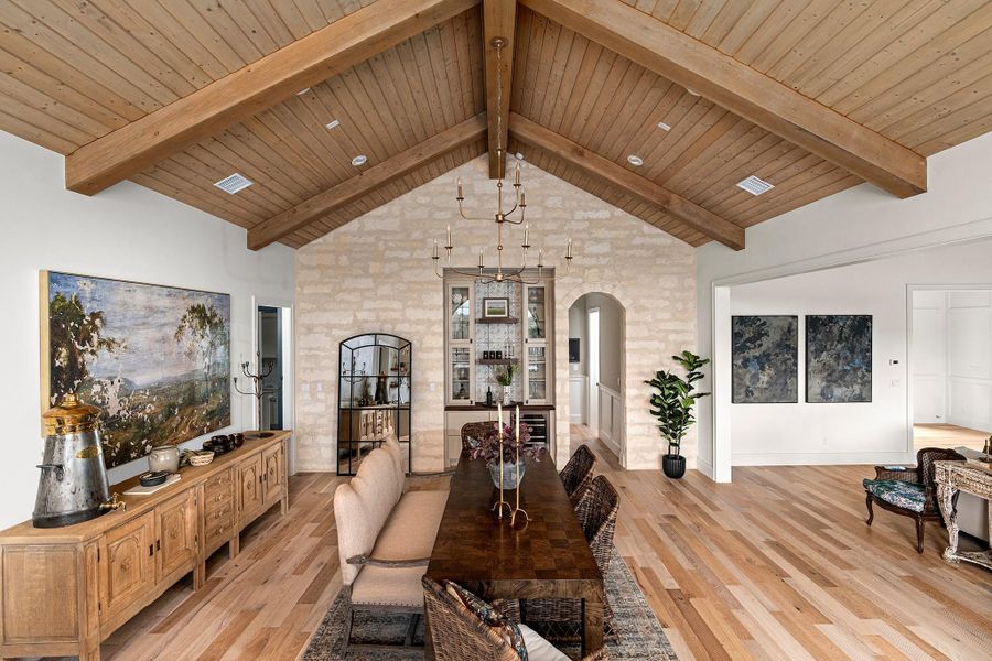 Dining space featuring light wood finished floors, wood ceiling, and arched walkways