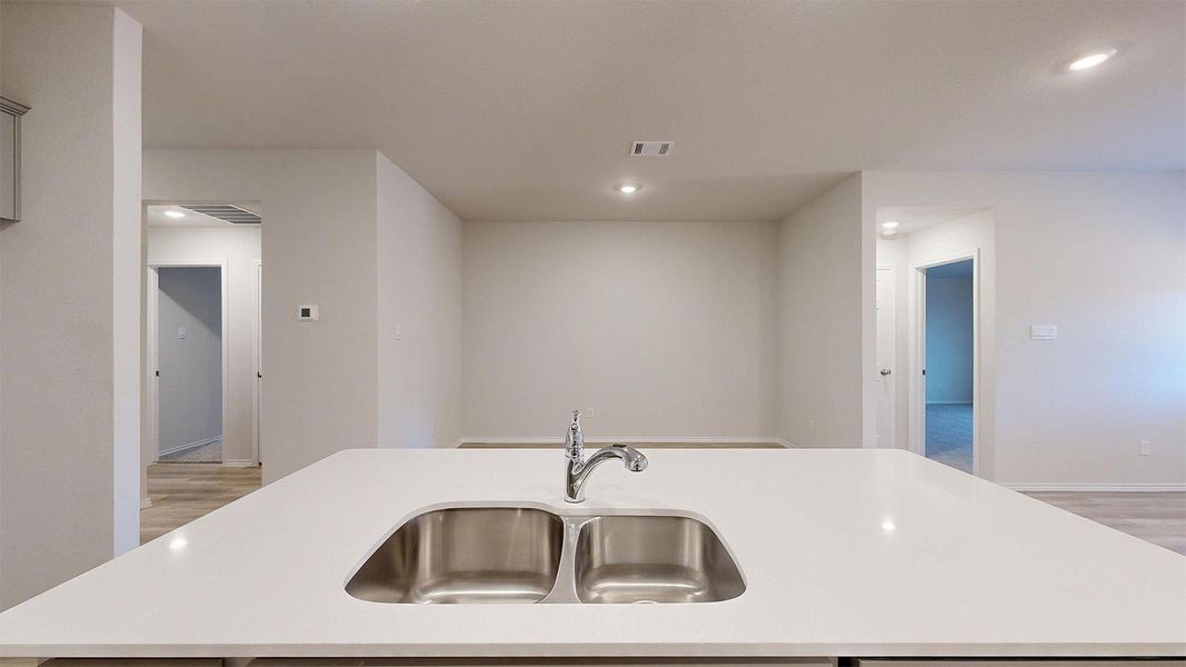 A pristine kitchen island with integrated stainless steel sinks, perfect for culinary endeavors.