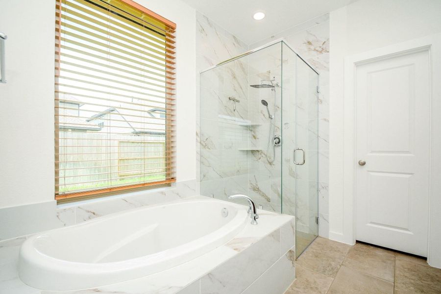 Spa inspired primary bathroom featuring a soaking tub, dual vanities, and a spacious walk in shower. Spa inspired primary bathroom featuring a soaking tub, dual vanities, and a spacious walk in shower.