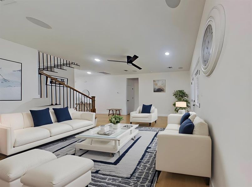 Living area with stairs, recessed lighting, a ceiling fan, and wood finished floors