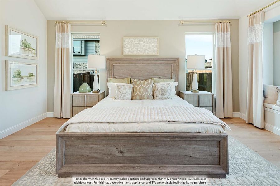 Bedroom with wood-frame bed, neutral bedding, two windows with curtains, and light hardwood floors
