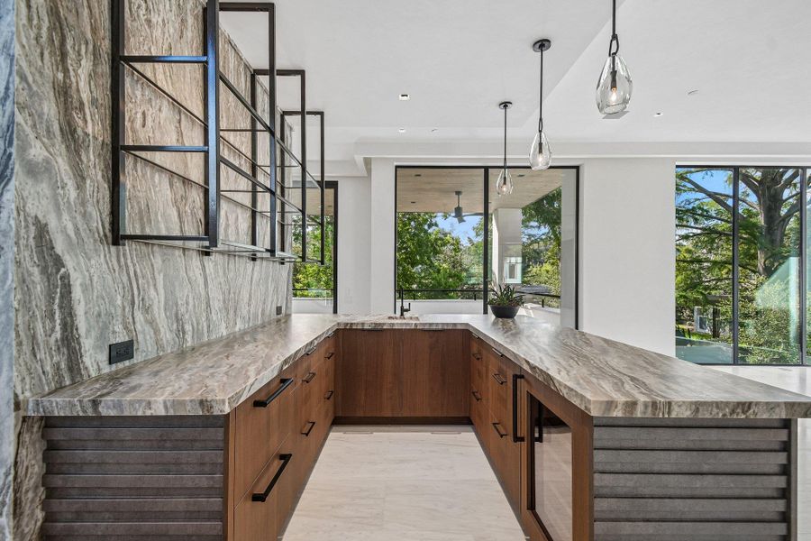 Rich wood cabinetry and dramatic stone countertops define this custom wet bar area. Rich wood cabinetry and dramatic stone countertops define this custom wet bar area.