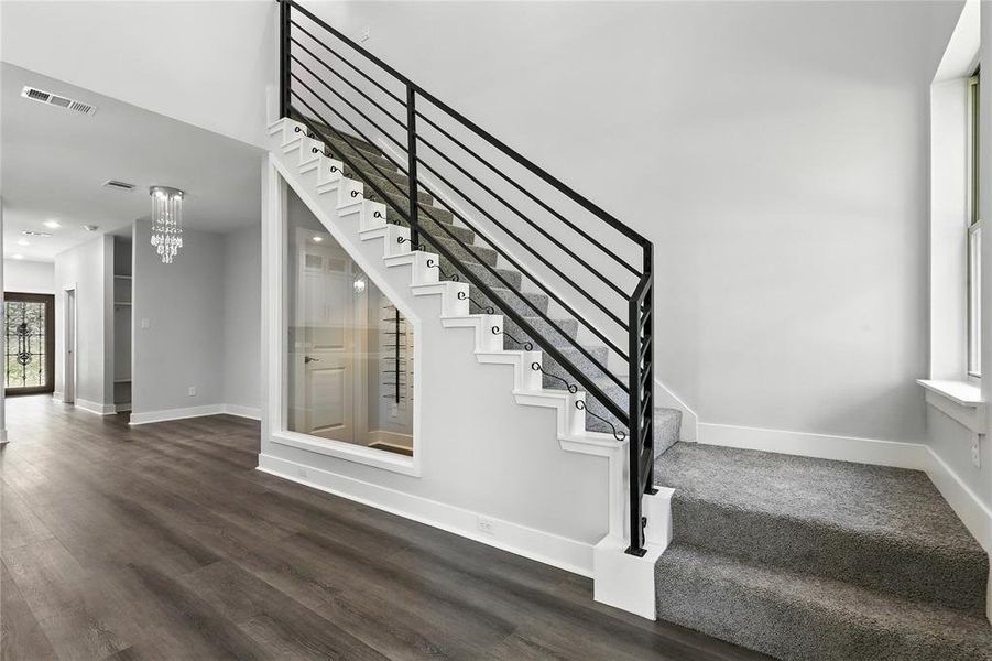 Stairway featuring wood finished floors and recessed lighting