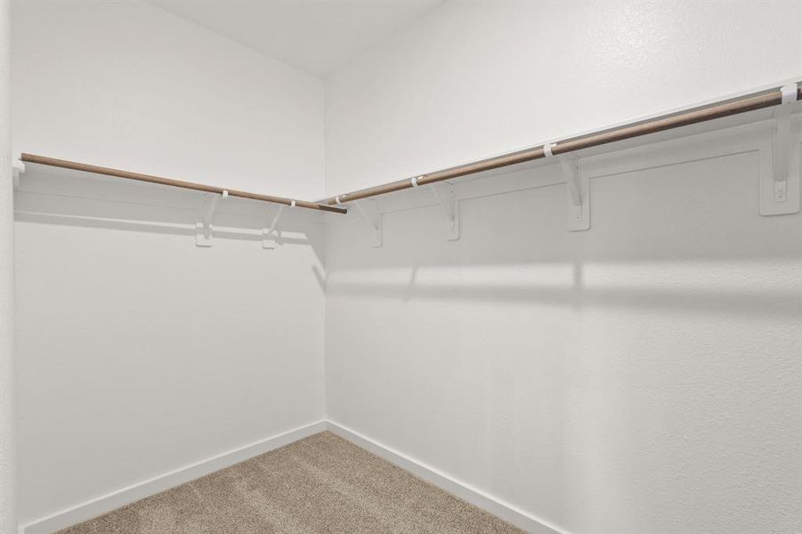 Walk in closet in the Prestigious Primary Suite offers an abundance of storage, hanging space and built-in shelving.