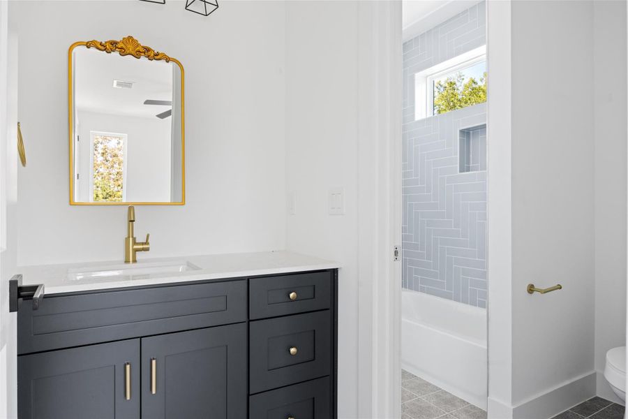 Full bath with vanity, light tile patterned flooring, and bathing tub / shower combination Full bath with vanity, light tile patterned flooring, and bathing tub / shower combination