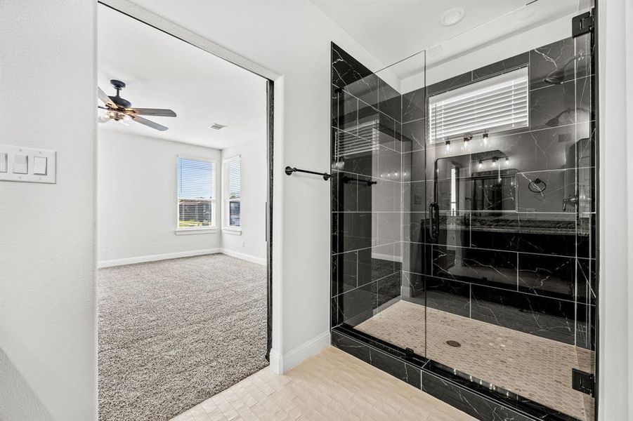 Bathroom with ceiling fan and a shower with door