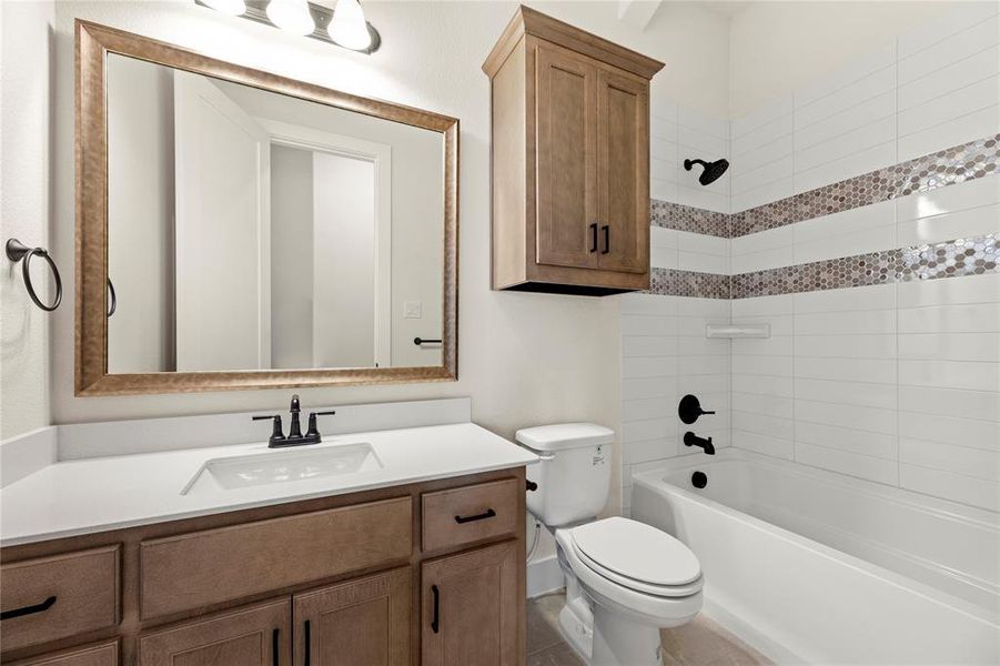 Full bathroom featuring vanity, toilet, and tiled shower / bath combo