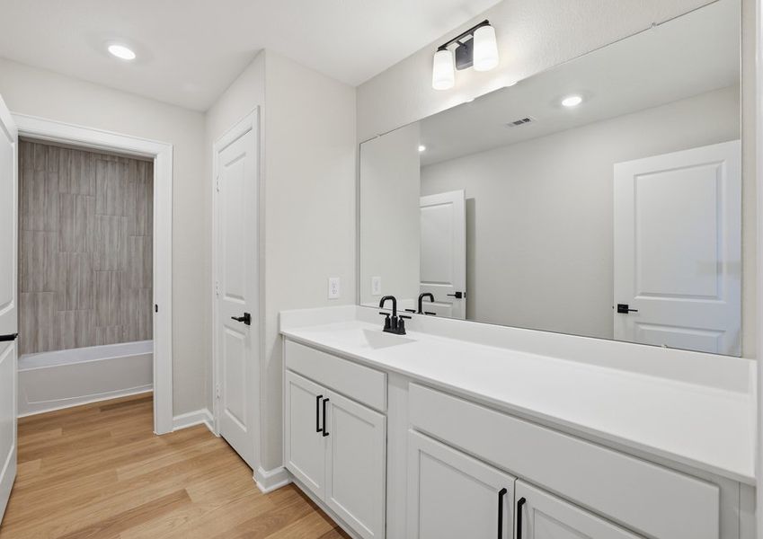 Secondary bathroom featuring a double vanity and cultured marble countertop.