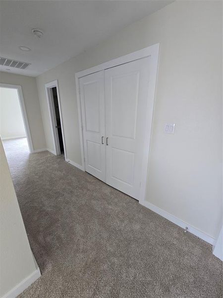 Unfurnished bedroom featuring carpet floors, baseboards, and a closet