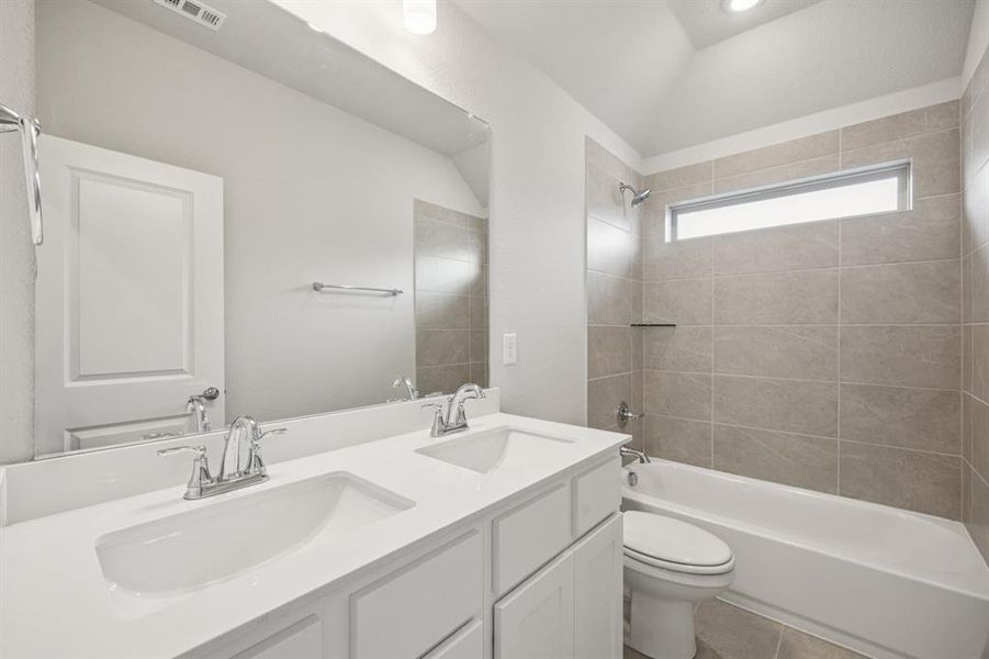 Full bathroom featuring double vanity, shower / bath combination, and tile patterned flooring Full bathroom featuring double vanity, shower / bath combination, and tile patterned flooring
