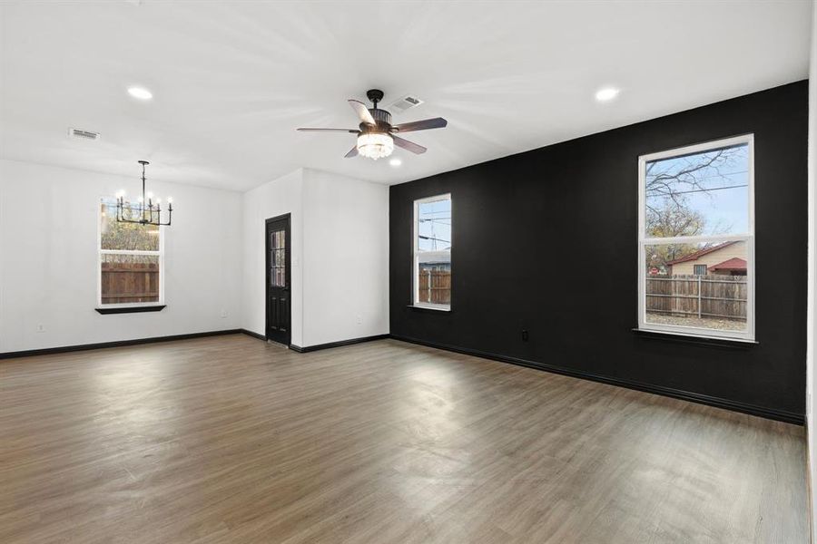 Living room featuring wood-type flooring and ceiling fan with notable chandelier