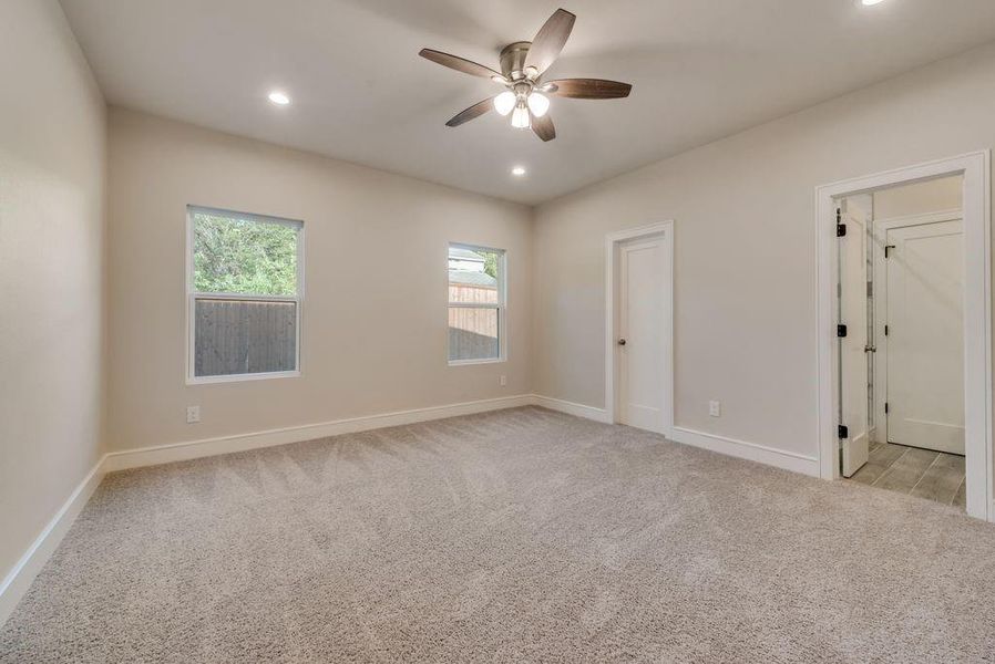 Carpeted empty room with ceiling fan